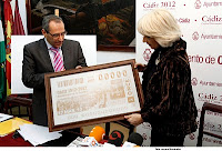 Teófila Martínez recibe la plancha del cupón de manos de Francisco Arroyo