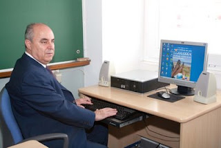 Francisco Galvan sentado frente a su ordenador en su clase