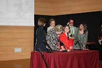 Una alumna deficiente visual le entrega a la hija de Blas Infante, María Ángeles Infante, un obsequio escrito en braille