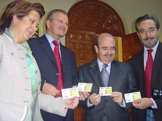 El delegado territorial de Andalucía y el consejero de la Presidencia muestran el Cuponazo dedicado a Tierras del Olivo junto al presidente de la Diputación de Jaén y la delegada de la Junta