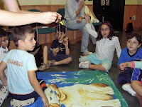 Imagen del taller de música con los menores atentos a las explicaciones de los monitores