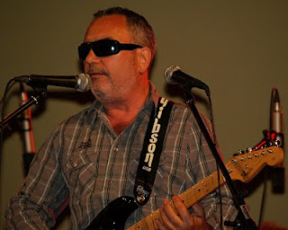 Primer plano de Cuder cantando con su guitarra