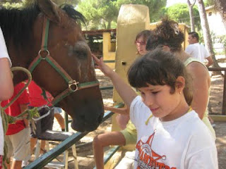Una de las niñas ciegas que asistieron a Fuerte Nagüeles acariciando a un caballo antes de montarlo