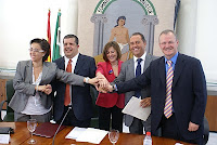 Los firmantes se cogen de las manos para la foto de familia tras la firma de los convenios