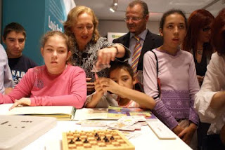 La presidenta del Parlamento rodeada de niños en uno de los stands de la EXPO Braille