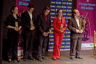 Foto de familia de los premiados con sus esculturas en las manos