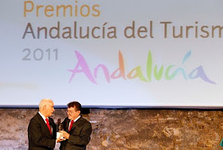 El director general de la ONCE, Ángel Sánchez, recoge el premio 'Embajador de Andalucía', de la mano del consejero de Turismo, Comercio y Deporte, Luciano Alonso