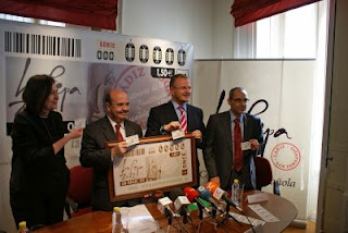 Gaspar Zarrías y Patricio Cárceles muestran a las cámaras la imagen del cupón del 28 de marzo