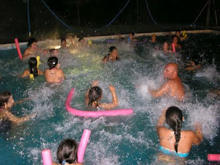 Baño nocturno en la piscina donde todos dusfrutan chapoteando