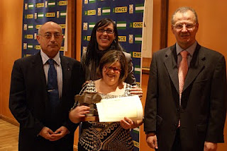 La ganadora del segundo premio de Relato Corto, María de la Paz Martínez Hornos, afiliada de la ONCE de Granada, por su obra ‘Empezar de nuevo’, posa sonriente mostrando su galardón