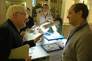 Dos miembros de la Junta Electoral conversan junto a una de las mesas electorales
