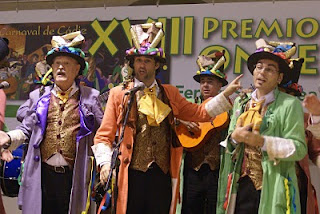 Colorista imagen de tres de los integrantes de la comparsa Medio Siglo durante su actuación