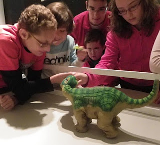Tres niños aprendiendo sobre la historia de los desaparecidos dinosaurios