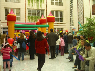 Niños subiéndose al castillo hinchable instalado en el patrio de la Delegación Territorial