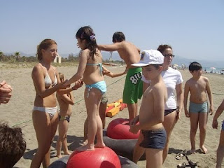 Varios niños están subidos sobre unas bolas enormes para aprender a mantener el equilibrio con la ayuda de sus monitoras