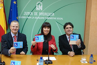 El delegado territorial de la ONCE en Andalucía, Patricio Cárceles, la consejera para la Igualdad y Bienestar Social, Micaela Navarro, y el director general de Discapacidad de la Junta de Andalucía, Gonzalo Rivas, presentan sonrientes la nueva tarjeta de aparcamiento para minusválidos