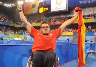 El granadino Tomás Piñas se muestra feliz con la bandera de España tras conseguir su medalla en tenis de mesa