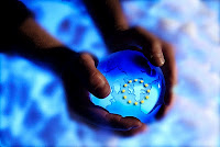 Unas manos cogen la bola del mundo con las estrellas de la bandera europea grabada