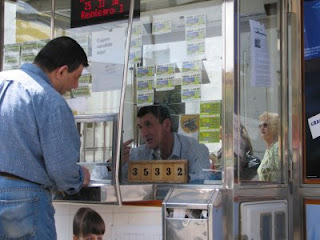 Francisco Cuesta en el interior de su kiosco vendiendo a un cliente