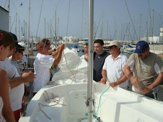 Los participantes amarrando cuertas en la embarcación