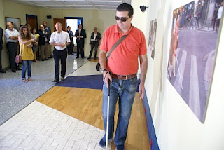 Un usuario haciendo uso del bastón en la sala de movilidad ante la atenta mirada de los invitados