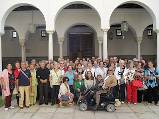 Foto de grupo de los excursionistas de la ONCE de Córdoba en el patio de la sede del Parlamento de Andalucía