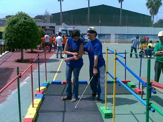 Un usuario con antifaz y bastón prueba a realizar el circuito de movilidad montado por la ONCE