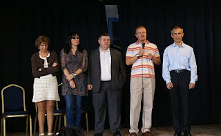 Sobre el escenario dirigiendo unas palabras al público la consejera territorial de la ONCE en Huelva, Josefa Barea,la presidenta del Consejo Territorial andaluz de la ONCE, Mónica Madrid, el consejero general de esta institución, Miguel Paraíso, el delegado territorial de Andalucía, Patricio Cárceles, y el director de la ONCE onubense, Antonio Casado