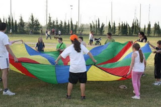 Varios pequeños con sus monitores juegan en el Parque del Alamillo