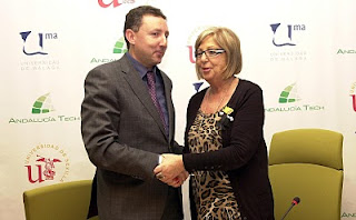 El director de la ONCE en Málaga, Cristóbal Martínez y la rectora de la Universidad de Málaga, Adelaida de la Calle sellando el convenio, simbólicamente, dándose la mano