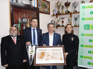 El director de la Agencia de la ONCE en La Línea, Juan Corbacho, el director de la ONCE en Algeciras, Alberto Ríos, presidente de la Balona, Alfredo Gallardo y la alcaldesa de La Línea de la Concepción, Gemma Araujo sostienen la imagen del cupón del centenario de la Balona
