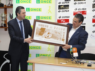 El director de la ONCE en Algeciras, Alberto Ríos entrega la copia de la plancha de la imprenta al presidente de la Balona, Alfredo Gallardo