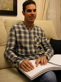 Primer plano de José Miguel leyendo en braille