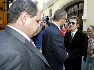 El cantante Raphael a las puertas de la sede de la ONCE en Jaén estrechando la mano del delegado territorial de la ONCE en Andalucía. En un segundo plano, les espera paciente el director provincial de la ONCE en Jaén, Pascual Gualda