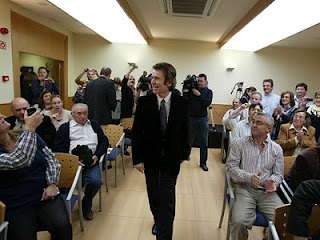 Raphael dirigiéndose por el pasillo central de la sala de prensa de la sede de la ONCE en Jaén hacía la mesa de interlocución