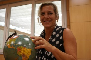 La directora de Viajes 2000 Sevilla posa sonriente con una bola del mundo en sus manos