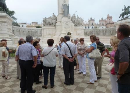 El grupo de trabajadores de la ONCE de Cádiz escuchan atentamente las explicaciones de una guía en la Plaza de España