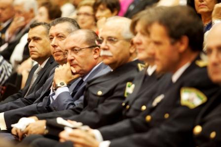 Julián León y Manuel Moreno sentados juntos a mandos policiales en el salón de actos de FIBES