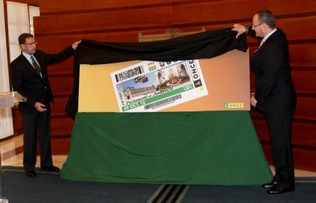 El delegado territorial de la ONCE en Andalucía, Ceuta y Melilla, Patricio Cárceles, destapa la imagen del cupón con la ayuda del presidente de la Mesa del Parlamento, Manuel Gracia