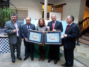La presidenta de la Asociación de la Prensa de Granada, Encarna Ximénez, muestra el cupón conmemorativo junto al delegado territorial de la ONCE y el alcalde de Granada
