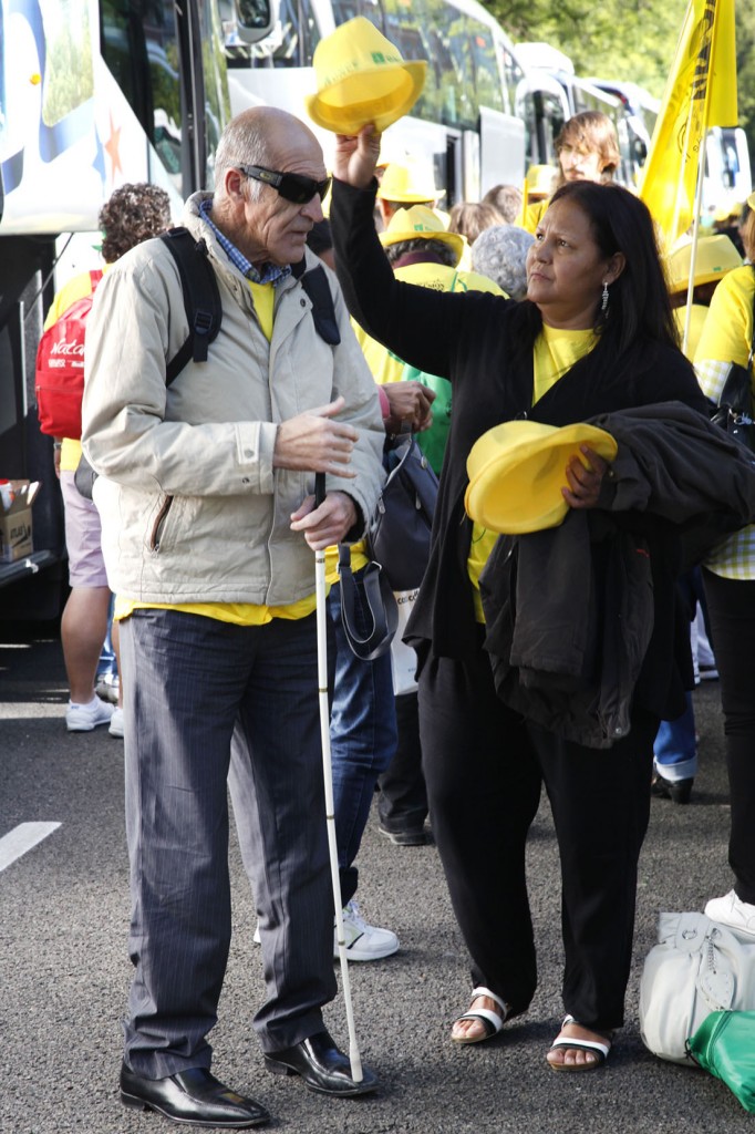 Una voluntaria ayuda a un afiliado a la ONCE