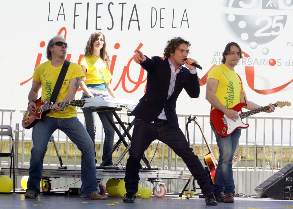 David Bisbal cantando con su mano derecha señalando al público