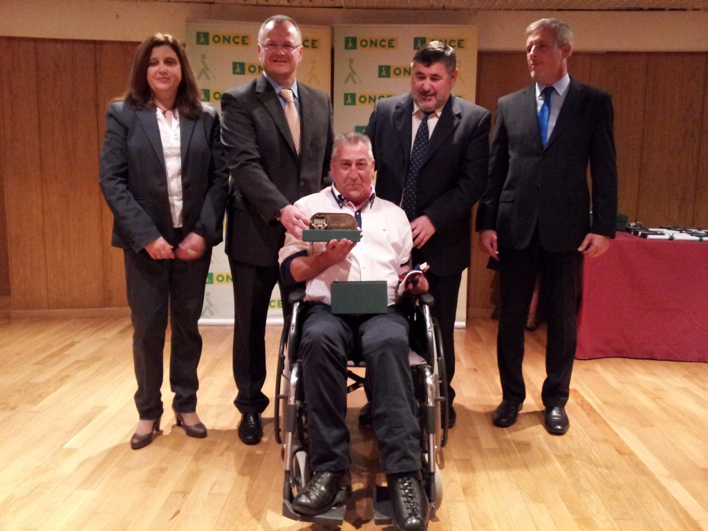 Entrega de condecoración a un jubilado de Granada de parte del delegado territorial de la ONCE, Patricio Cárceles, el vicepresidente del Consejo Territorial, Francisco Javier Fernández Bustos, y el director de la ONCE en Granada, Alberto Morillas