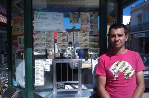 En la imagen, el vendedor Vicente Tizón posa frente a su kiosco de la ONCE desde el que ha dado el premio