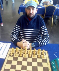 En la imagen, plano medio de Zanoletty mirando a cámara junto a un tablero de ajedrez