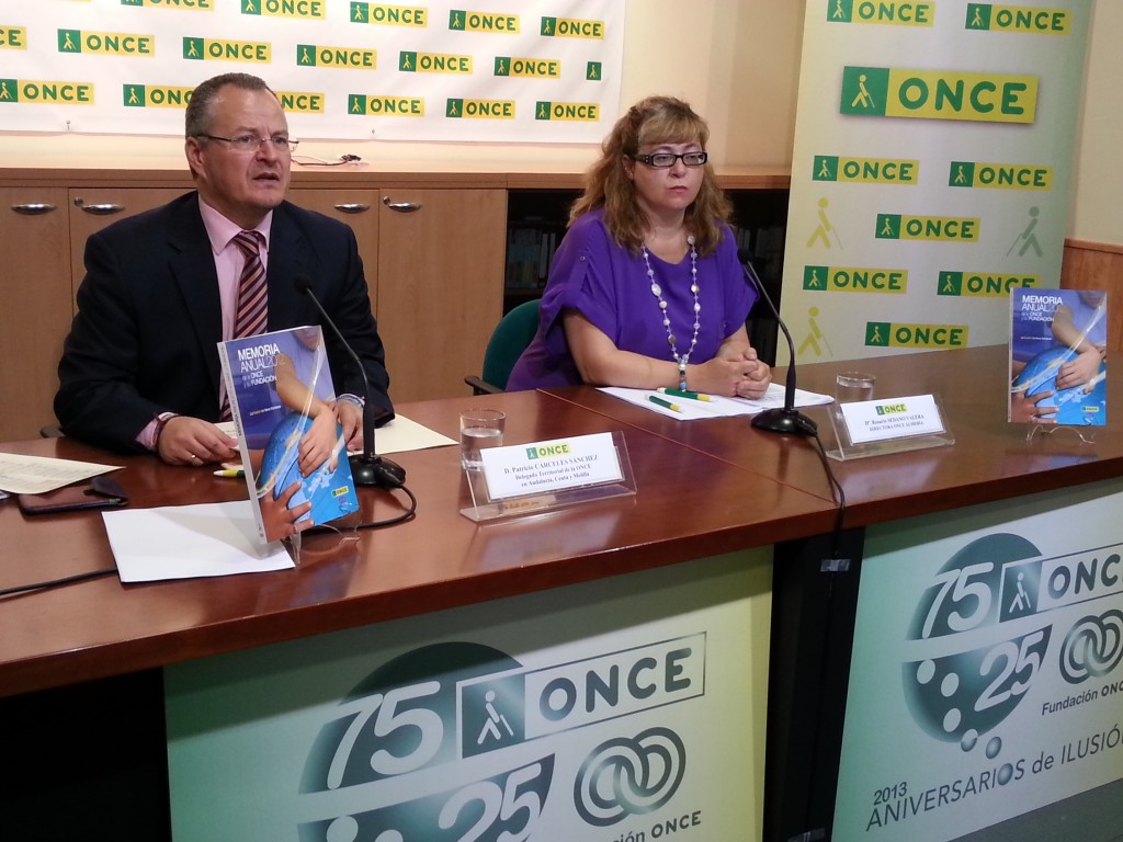 El delegado territorial de la ONCE en Andalucía, Ceuta y Melilla, Patricio Cárceles, junto a la directora de la ONCE Almería, Rosario Sedano, enseñando el libro de la memoria