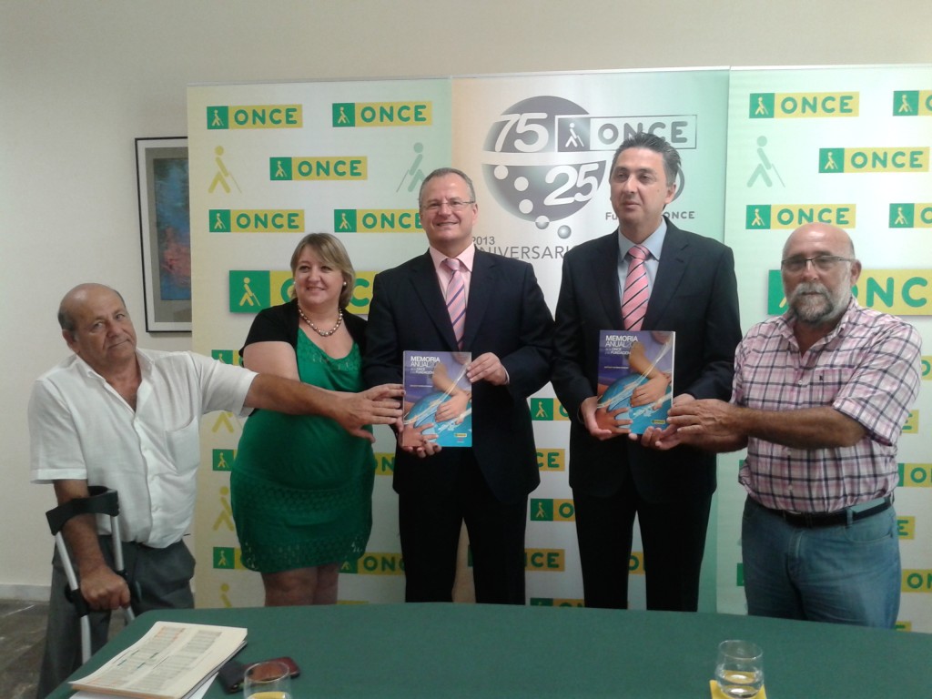 Foto de familia en la que los trabajadores de ONCE Algeciras muestran a cámara los libros sobre la memoria económica y social