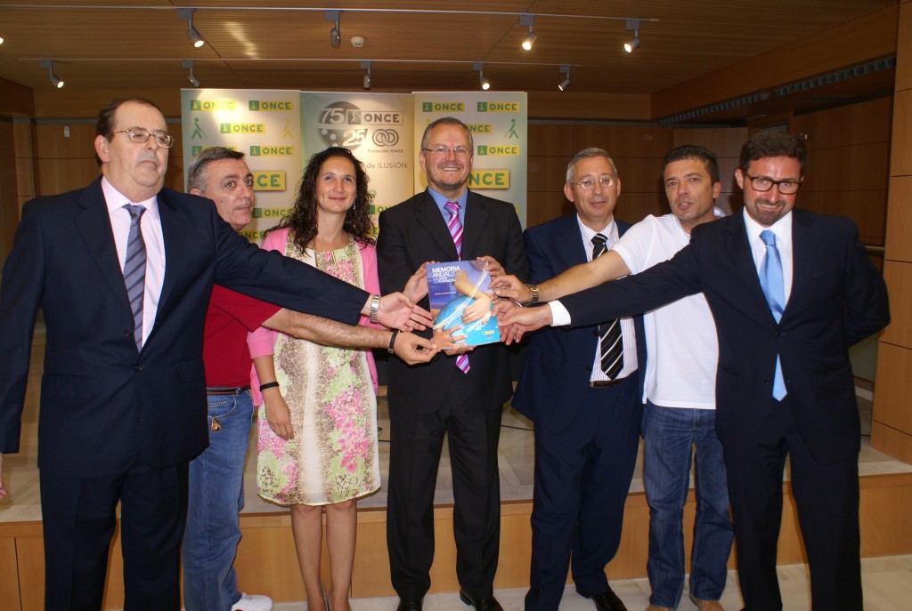 Foto de familia en la que los trabajadores de ONCE Cádiz muestran a cámara los libros sobre la memoria económica y social