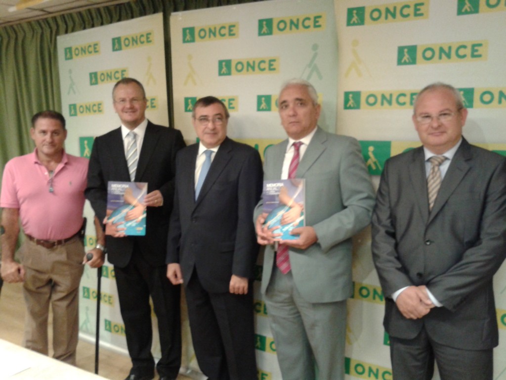 Foto de familia en la que los trabajadores de ONCE Huelva muestran a cámara los libros sobre la memoria económica y social