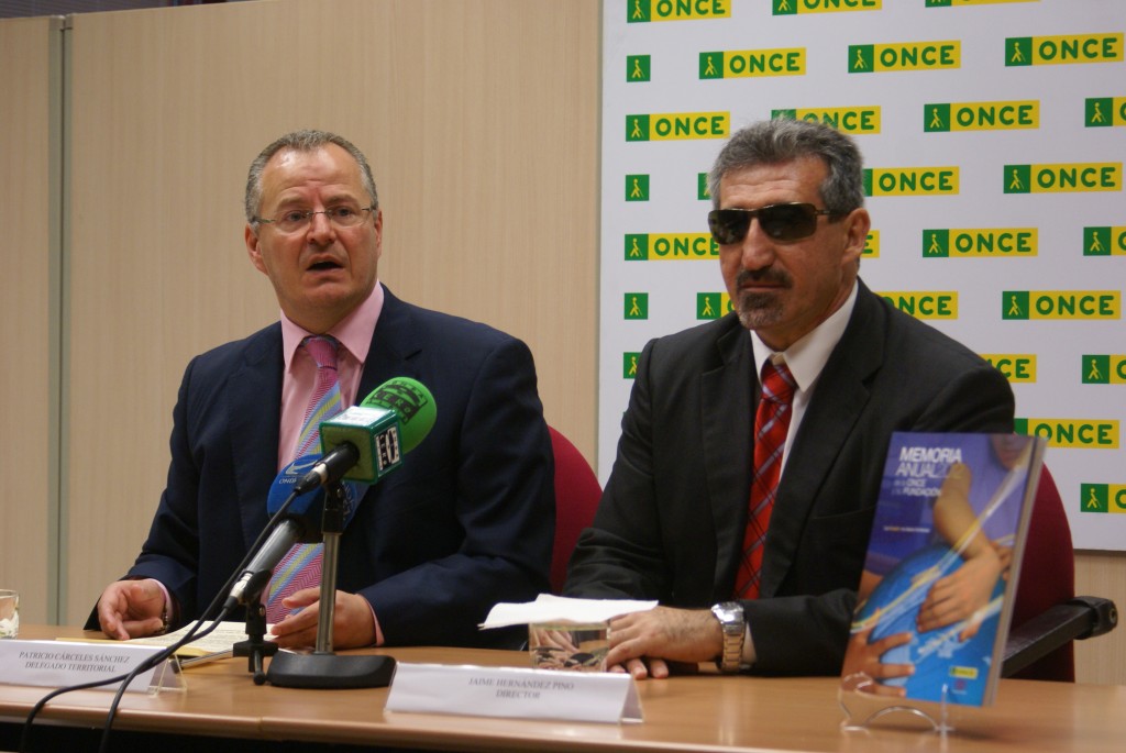 El delegado territorial de la ONCE en Andalucía, Ceuta y Melilla, Patricio Cárceles, junto al director de la ONCE Jerez, Jaime Hernández, enseñando el libro de la memoria